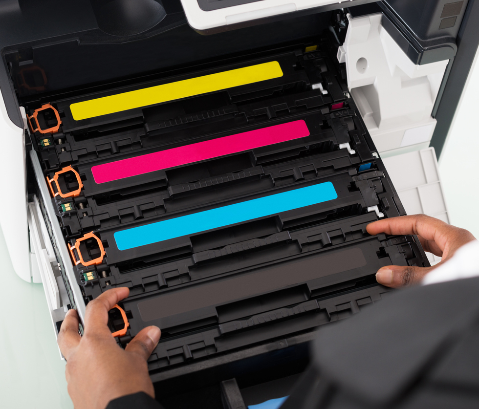 Businesswoman Fixing Cartridge In Office